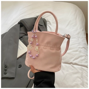 Pink pleated bucket bag with floral bead charm detail and woven design element