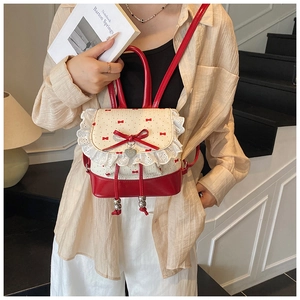 Detail showing red leather and polka dot lace trim with a heart pendant on the backpack