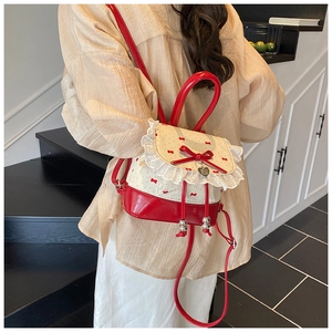 Close-up of red and white mini backpack with lace edges and a heart-shaped metal pendant