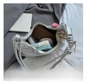 Vue intérieure montrant la capacité du sac hobo argenté avec portefeuille et maquillage