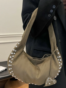 Sac hobo demi-lune en daim vert olive avec clous et breloque cœur sur un mannequin
