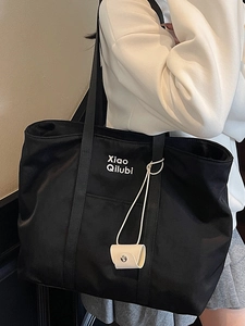 Grand sac fourre-tout en toile noire avec lettrage blanc et pendentif mignon en situation