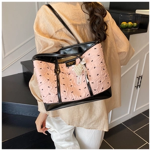 Détail du sac cabas rose avec motifs de nœuds noirs et pendentif en perles élégant