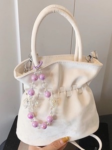Elegant cream pleated bucket bag with decorative purple bead butterfly charm and strap