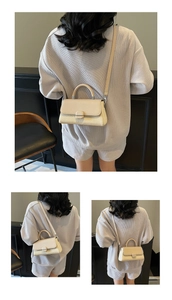 Detail of cream crossbody bag featuring mixed smooth and woven texture with top handle