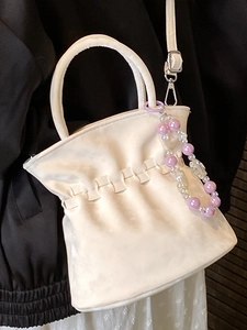 Elegant white pleated bucket bag with round handle and decorative purple bead charm
