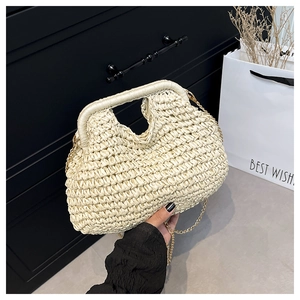 Close-up of beige woven cloud bag with structured top handle and gold chain strap
