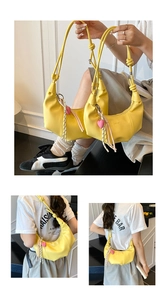 Détail du sac hobo jaune avec bandoulière nouée et breloque en forme de cœur rose