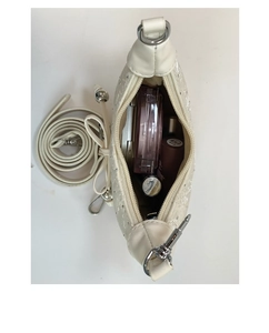 Interior view of white crescent bag showing storage space for lipstick and makeup