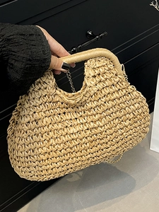 Handwoven straw tote bag with leather-wrapped handles and a sleek metal chain strap