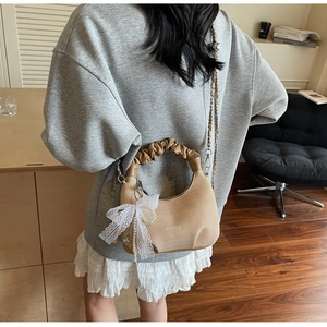 Détail du sac coquillage kaki avec poignée plissée et nœud en dentelle perlé