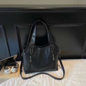 Close-up of black lychee texture tote bag with parallel silver zippers and dual straps