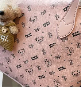 Gros plan du sac fourre-tout rose avec motif d'ours et joli porte-clés en peluche