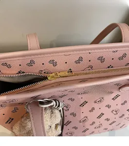 Gros plan de la fermeture éclair dorée sur un sac cabas rose avec motifs d'oursons