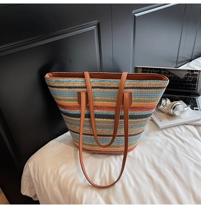 Detail der bunten Strohtextur und der hochwertigen braunen Lederriemen der Strandtasche