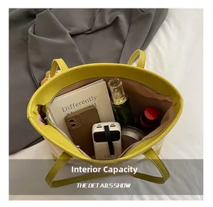 Top view of spacious interior of canvas tote bag with books, phone and zipper closure