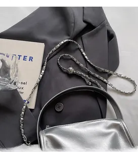 Detail der silbernen Umhängetasche mit Metallkette und verstellbarer Kugelschließe