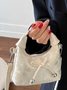 Chic beige bow dumpling bag with silver micro-shimmer texture and delicate rivets