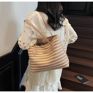 Détail de la texture du sac cabas en paille avec bandoulière et poignée en cuir