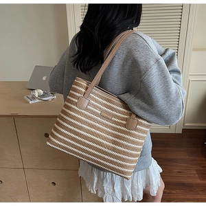 Détail du sac cabas rayé en paille avec bandoulières en cuir marron et étiquette