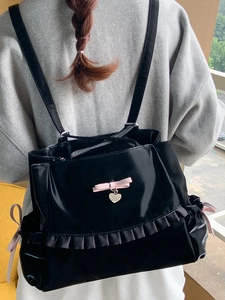 Glossy black patent leather tote bag with pink bows and ruffle trim for women