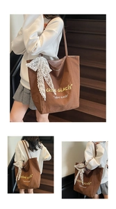 Detail of brown canvas tote bag with lace bow decoration and French text on front