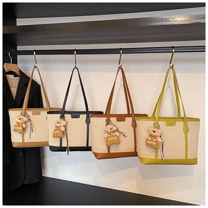 Detail view of canvas tote bags in four colors with leather trim and plush bear charms