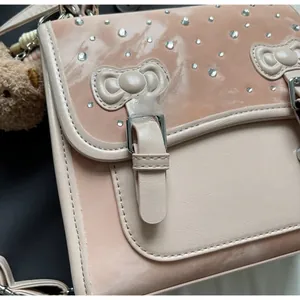 Detail of light pink bag featuring glossy leather texture and sparkling diamond accents