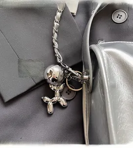 Detailansicht eines silbernen Ballonhund-Anhängers an einem metallischen Kettengurt