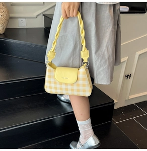 Détail du sac à main à carreaux jaune et blanc avec poignée en cuir tressé unique