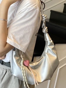 Silver crescent shoulder bag with knot straps and heart charm in a trendy summer style