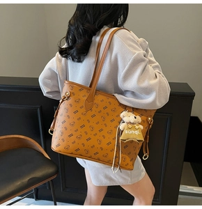 Détail d'un grand sac cabas en cuir marron avec motifs d'ours et un joli pendentif peluche