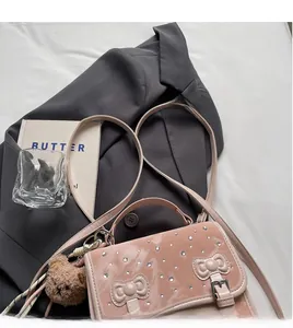 Pink patent leather shoulder bag with bow details and a cute plush bear charm