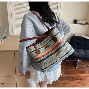 Détail du sac cabas en paille arc-en-ciel avec poignées en cuir marron et étiquette