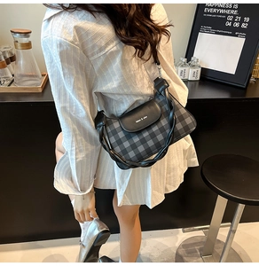 Détail d'un sac à damier avec une poignée unique en cuir noir torsadé élégante