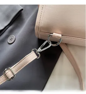 Detailed close-up of premium silver metal buckles and adjustable strap on a leather bag