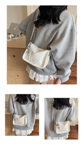 Detailaufnahme einer weißen glänzenden Umhängetasche mit Silberkette und MOOK-Tag