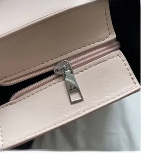 Close-up of smooth silver metal zipper and premium pink leather texture on backpack