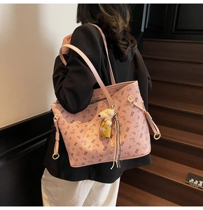 Détail du cabas en cuir rose avec motifs d'ours et un adorable pendentif d'ourson