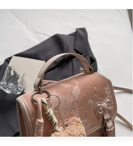 Pink sweet-style handbag featuring sparkling rhinestones, bow clasp, and plush bear charm