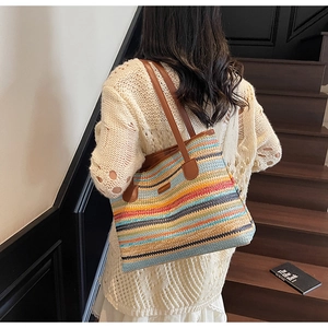 Détail du sac cabas tissé à rayures multicolores avec des anses en cuir marron