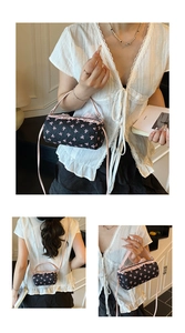Detail of black barrel bag featuring pink bow embroidery and ruffled edge trim