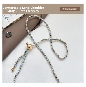 Detail of light blue leather chain strap with golden metal ball adjuster and ball pendant