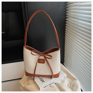 Detail showing woven texture and leather trim with bow knot on a summer beach tote bag