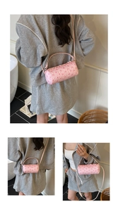 Detail of pink cylindrical handbag with 3D floral texture and metallic zipper accents