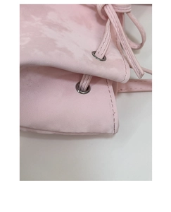 Gros plan sur le sac rose marbré avec œillets métalliques argentés et cordon de serrage