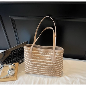 Détail du sac fourre-tout rayé en paille avec lanières en PU et plaque en métal