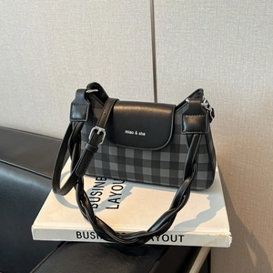 Détail du sac sous le bras à carreaux gris avec poignée tressée et bandoulière réglable