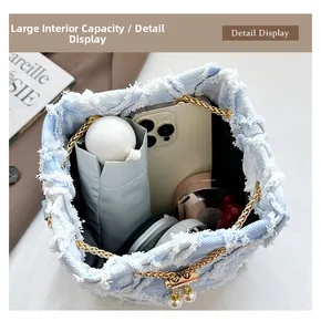 Detail view of large capacity denim bucket bag interior with golden chain and pearls