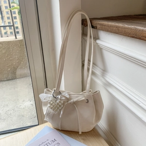 Détail du sac bandoulière blanc crème en similicuir avec nœud dentelle et pendentif perle